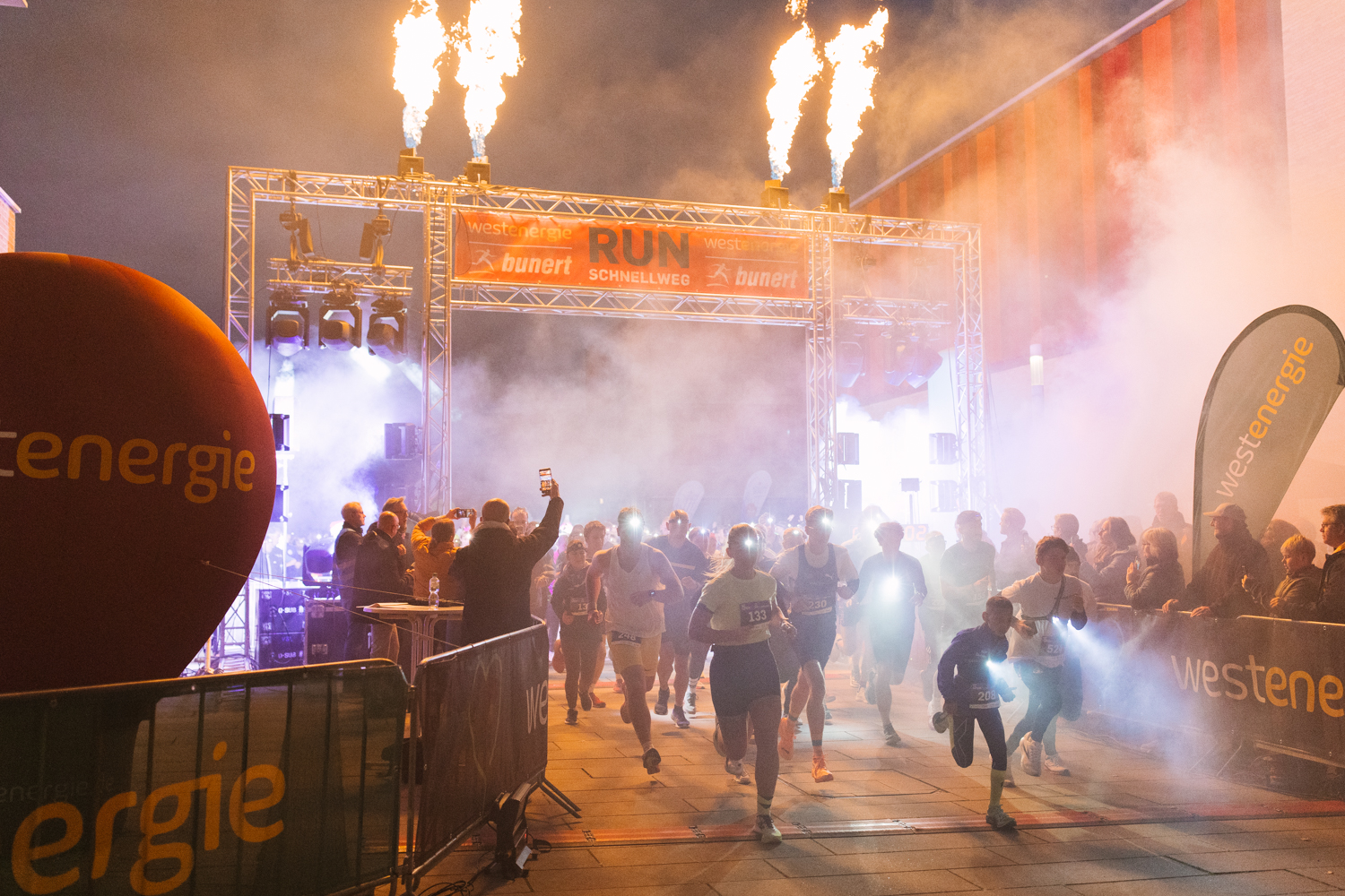 Start des RUNschnellweg mit Pyro-Effekten und Nebel vor dem Westenergie-Bogen