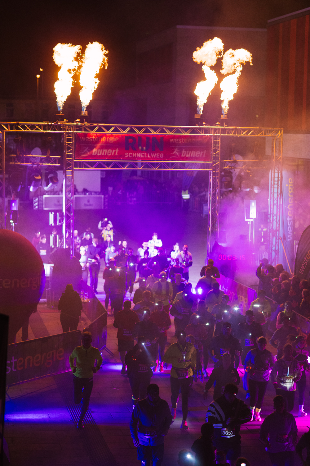 Menge vor der Bühne in pinkem und violettem Licht beim Start